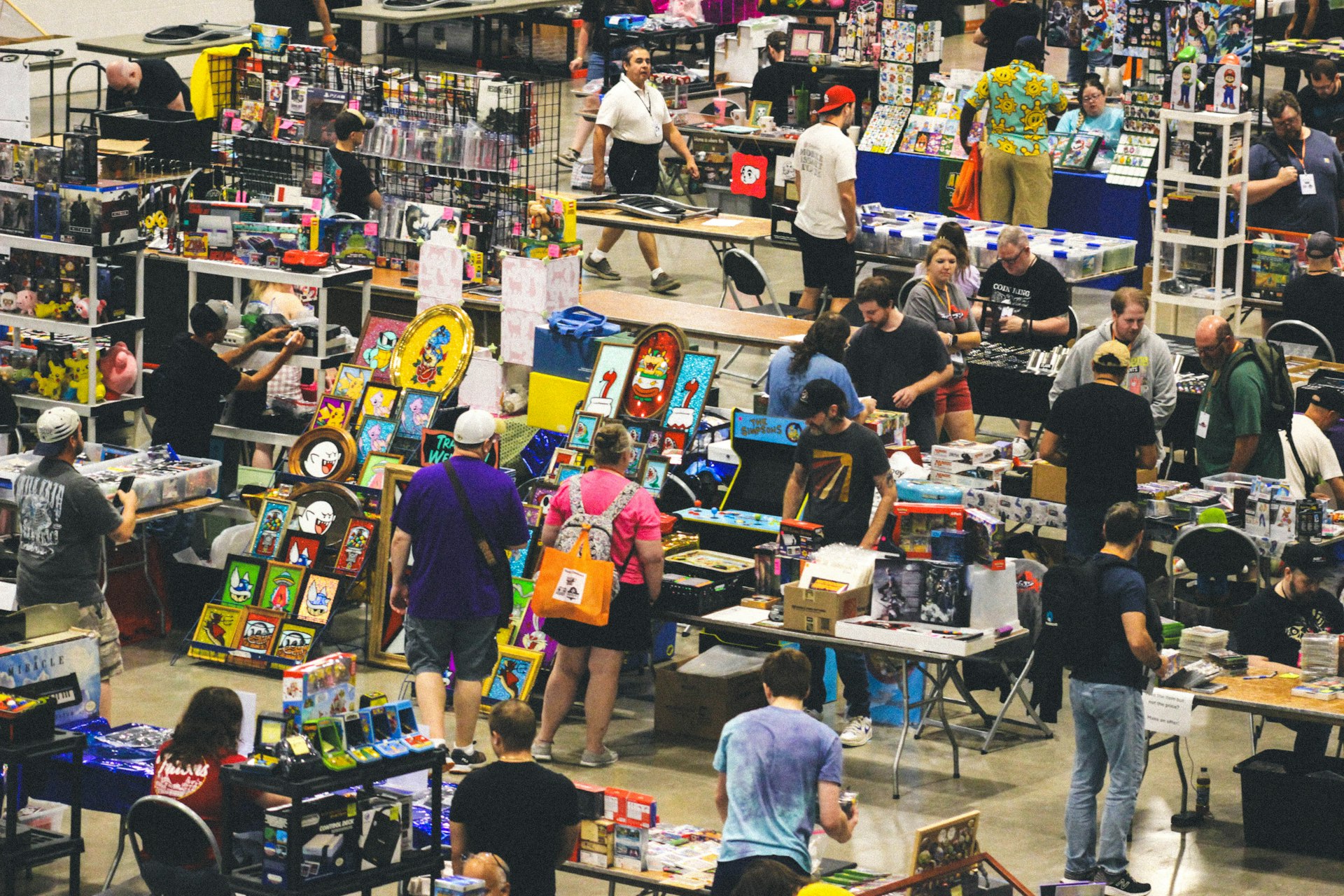 Crowded indoor market with many people browsing merchandise stalls